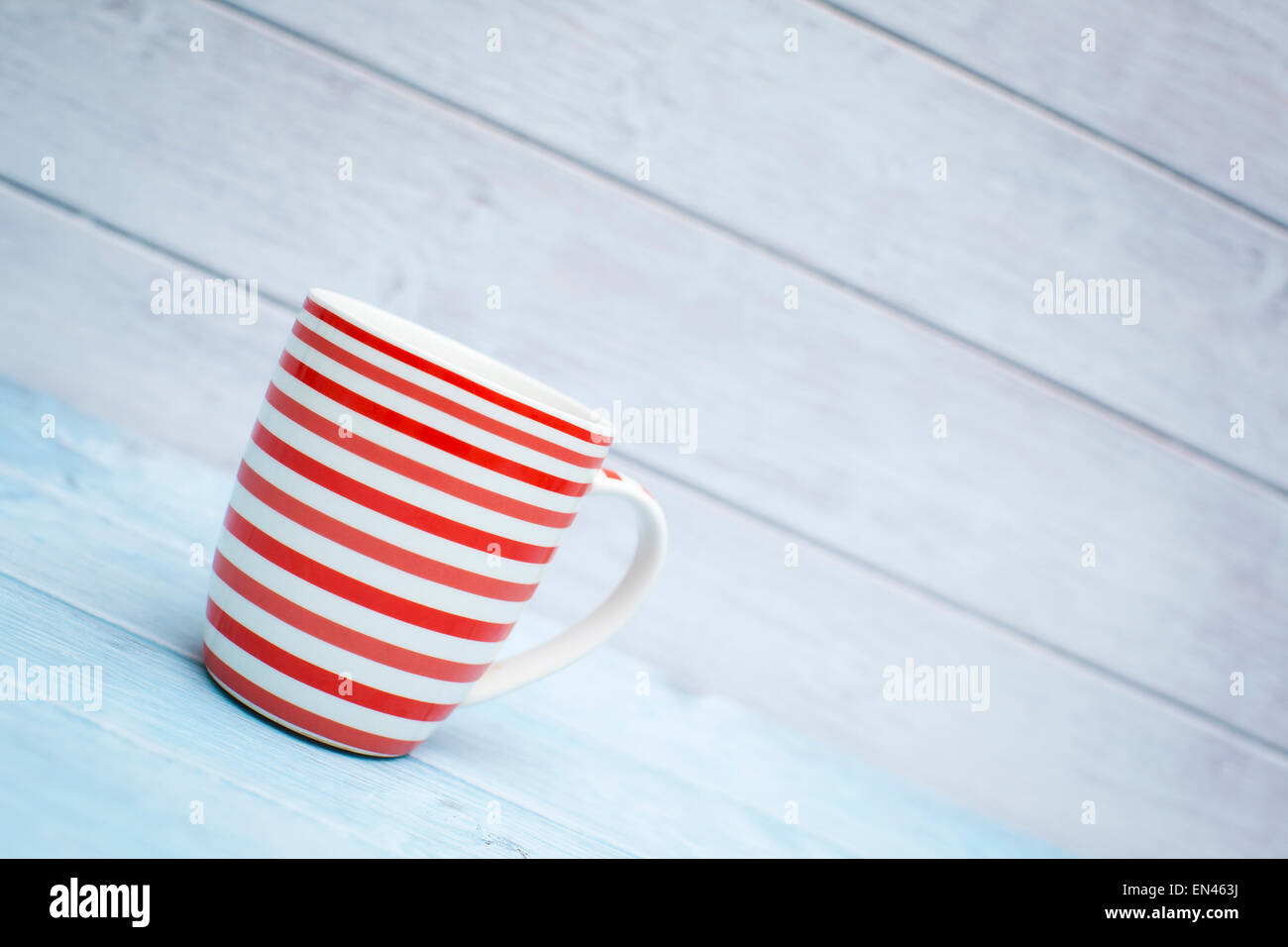 Bunte Tassen auf einem hölzernen Hintergrund Stockfoto