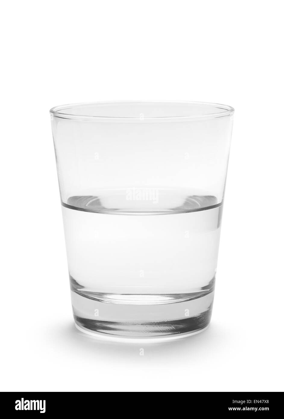 Kleines Glas Wasser halb voll auf weißem Hintergrund isoliert. Stockfoto