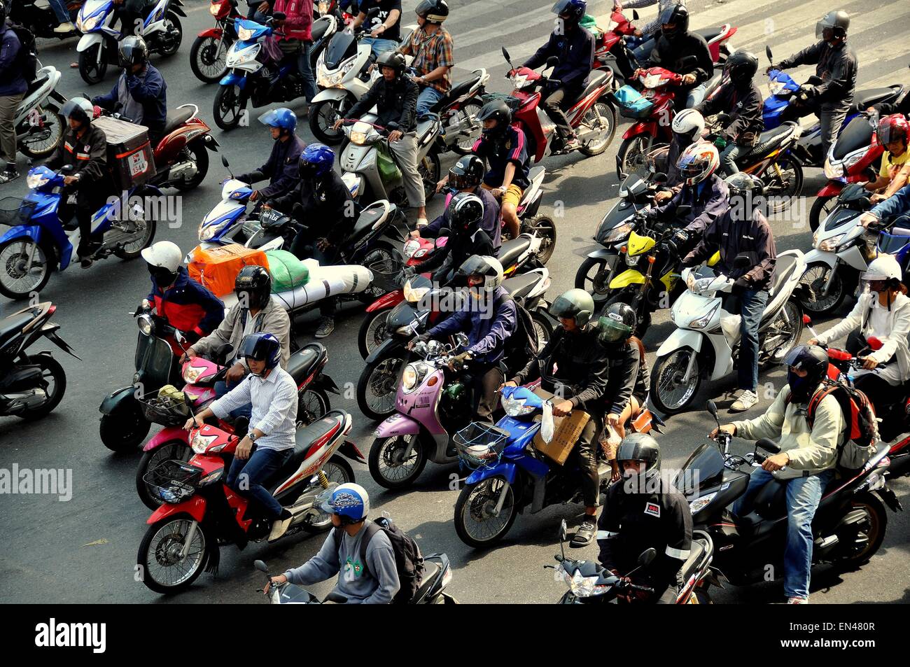 Bangkok, Thailand: Motorrad und Mopedfahrer, alle tragen Verordnung Helme, warten, bis ein rotes Licht zu ändern Stockfoto