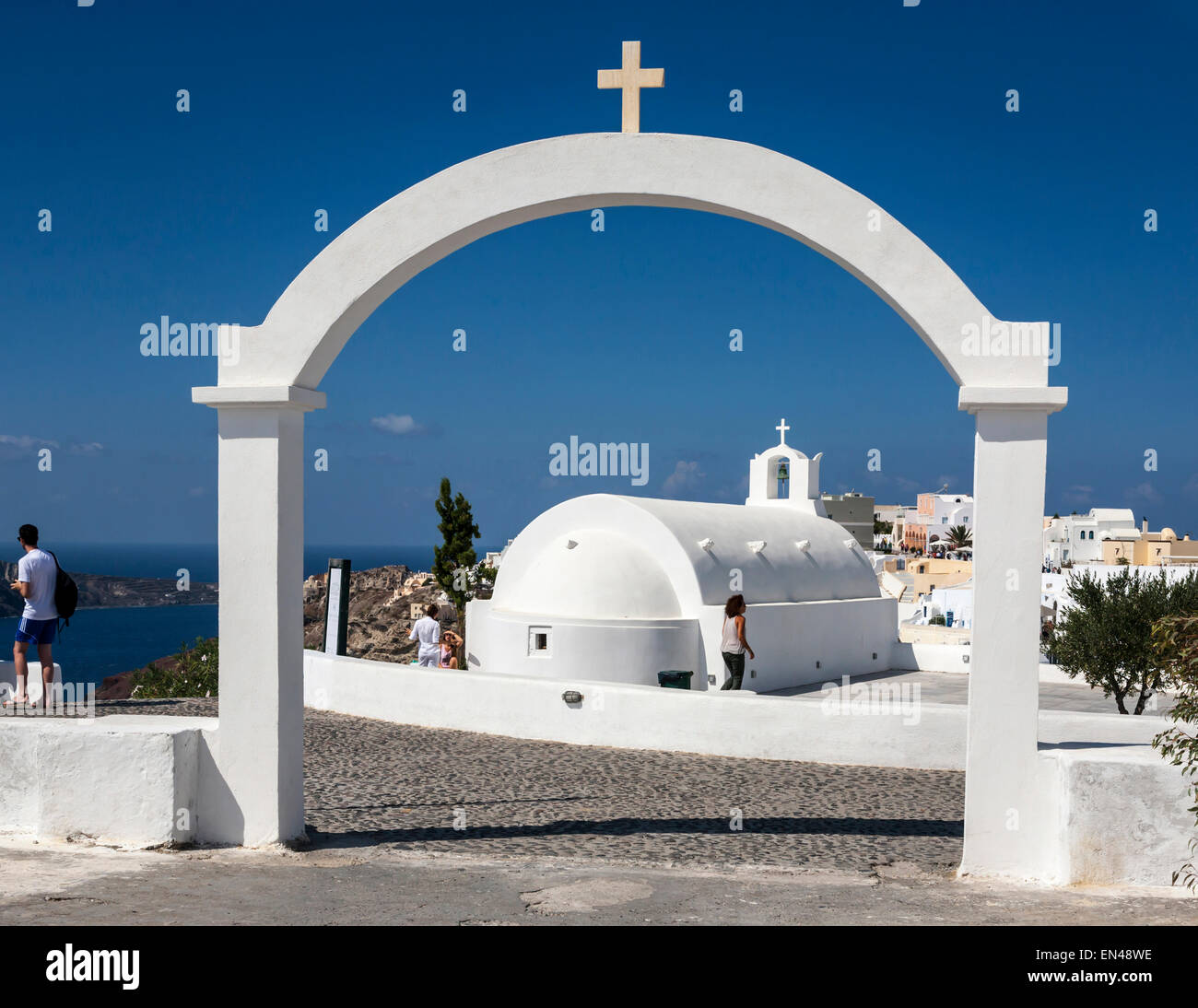Kleine weiße Kirche eingerahmt durch einen Torbogen, Oia, Santorini (Thera), Griechenland. Stockfoto