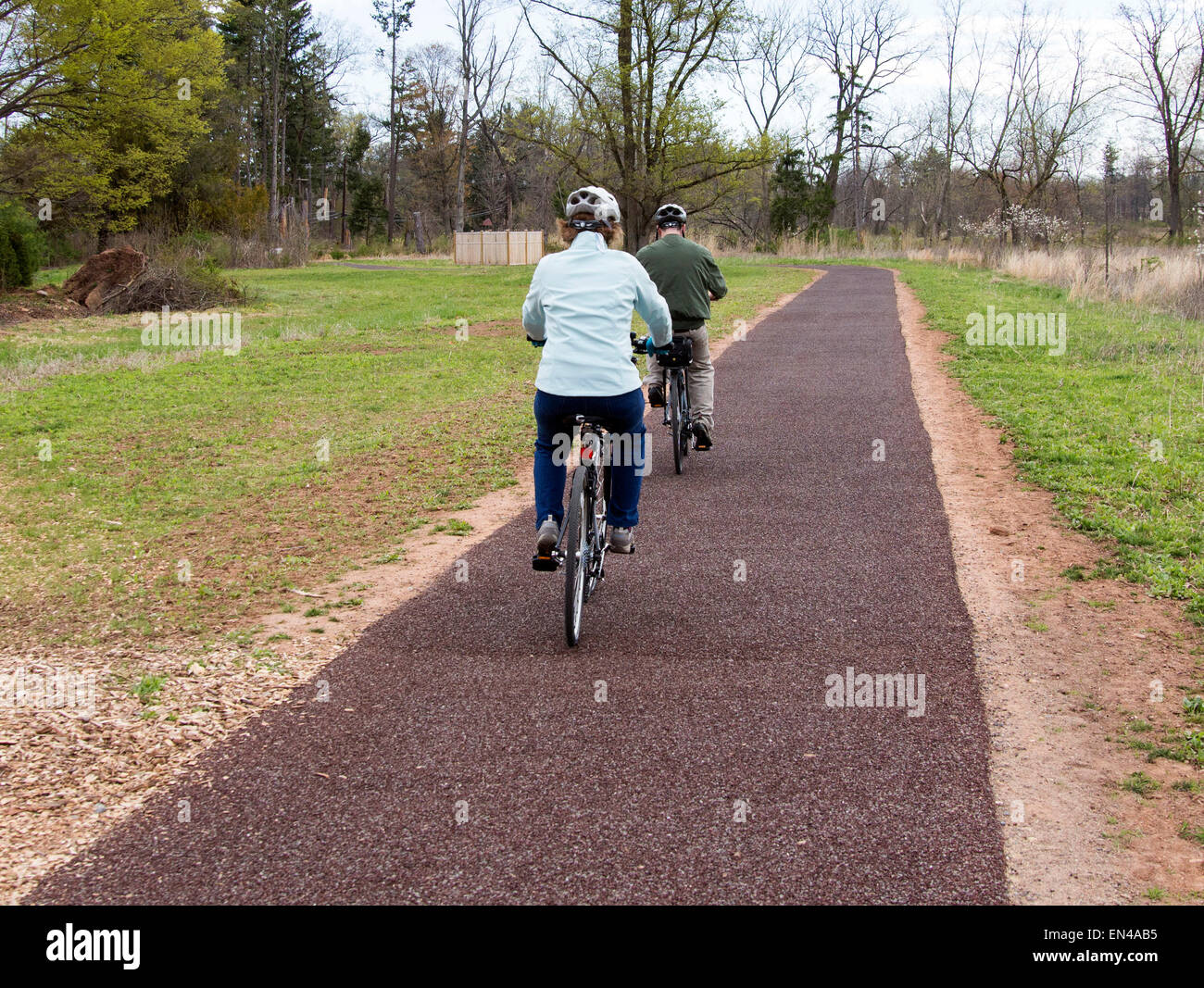 Paar senior Mann und Frau auf Fahrrädern auf einem gepflasterten Weg in den Park. Stockfoto