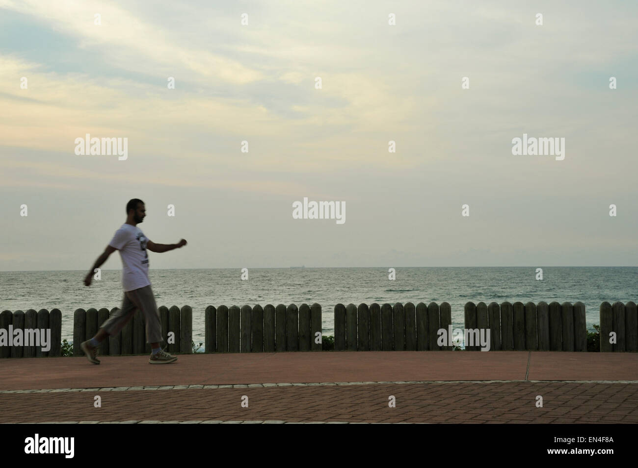 Durban, KwaZulu-Natal, Südafrika, einem erwachsenen Mann zu Fuß auf der Promenade, schwingen die Arme, Strand, Leute, Landschaft Stockfoto