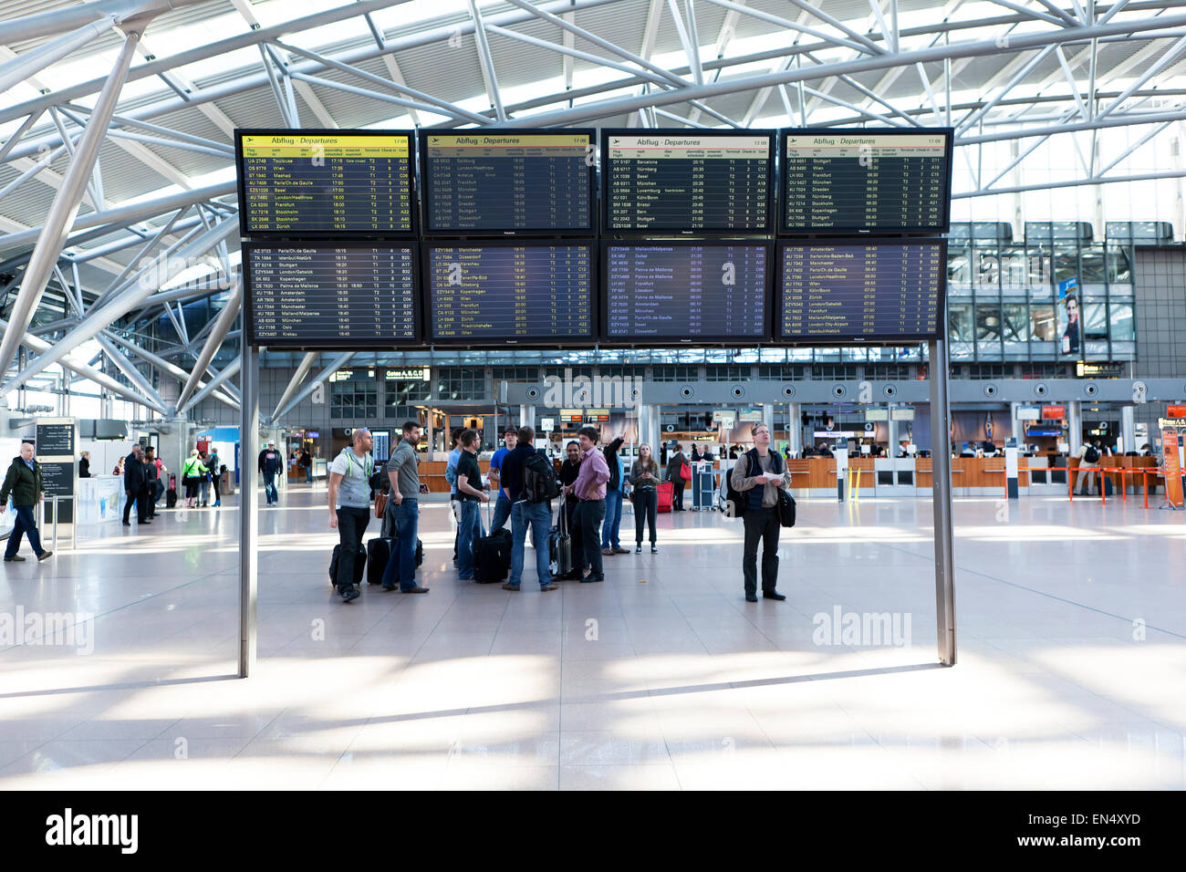 Abflug-Lounge am Flughafen Hamburg mit Fluginformationen und touristischen Stockfoto