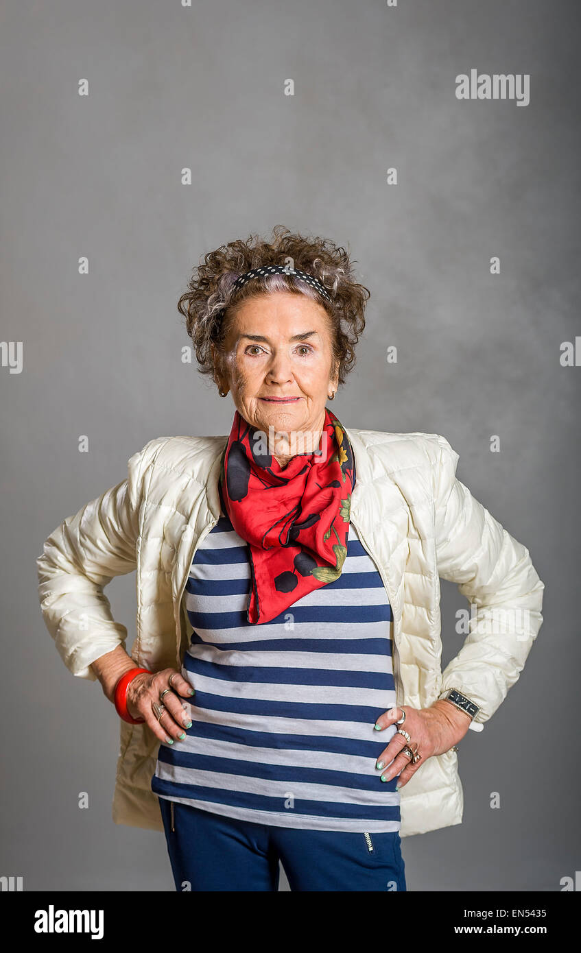 Studioportrait von 83 alte suchen gute weiße senior Frau auf grauem Hintergrund Stockfoto