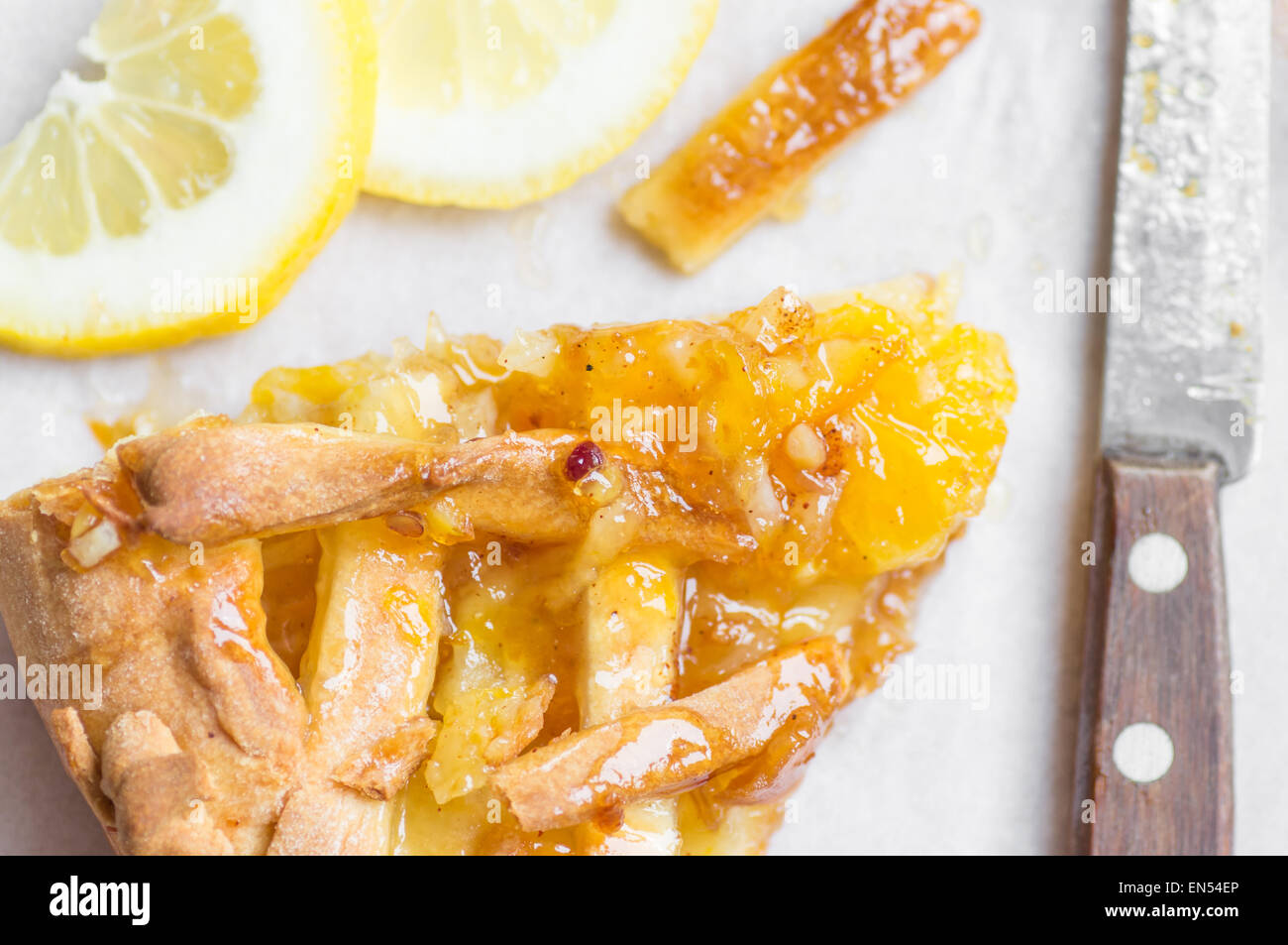 Stück Limonentarte mit Zitrone und Messer Draufsicht auf den Tisch Stockfoto