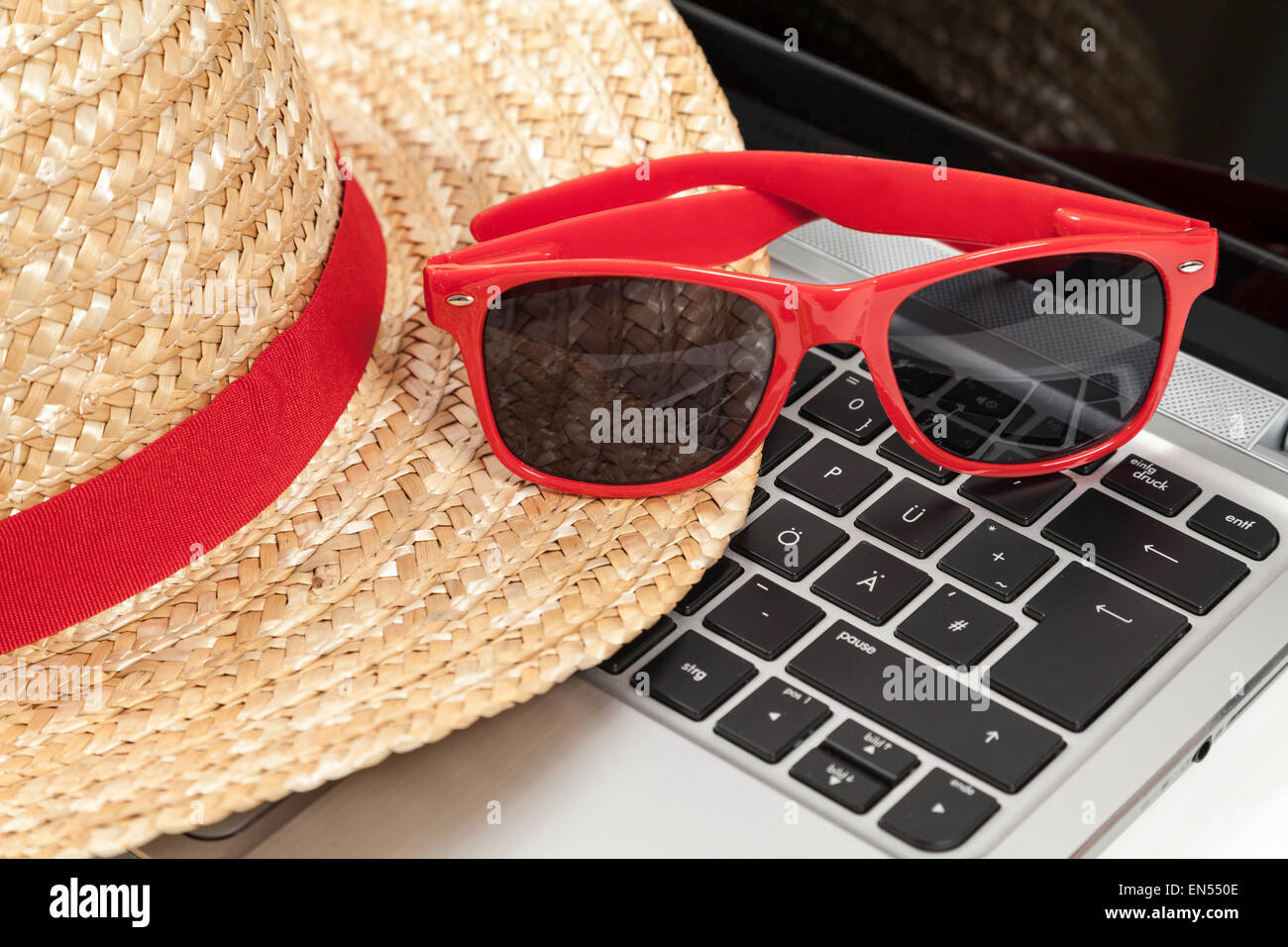 Stroh Hut, Sonnenbrille und laptop Stockfoto