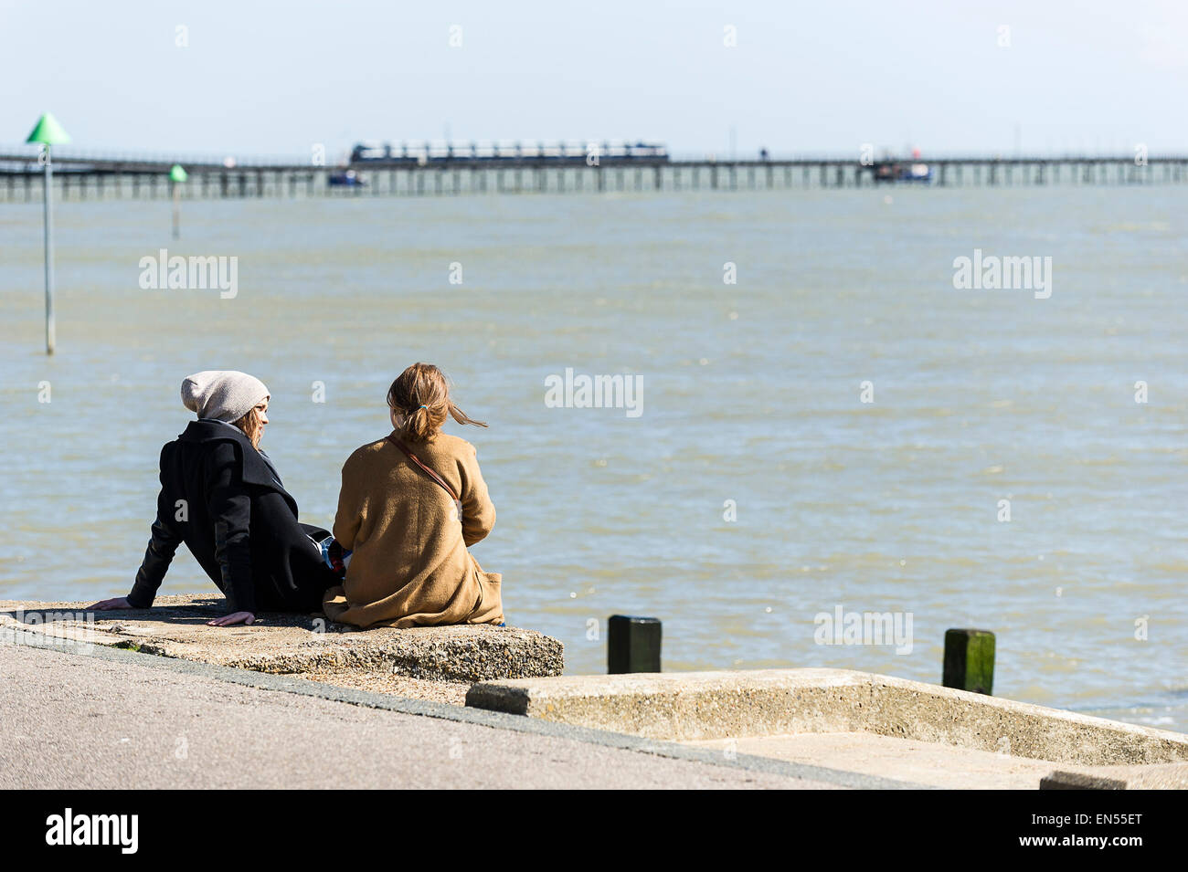 Zwei Freundinnen Entspannung direkt am Meer in Southend, Essex. Stockfoto