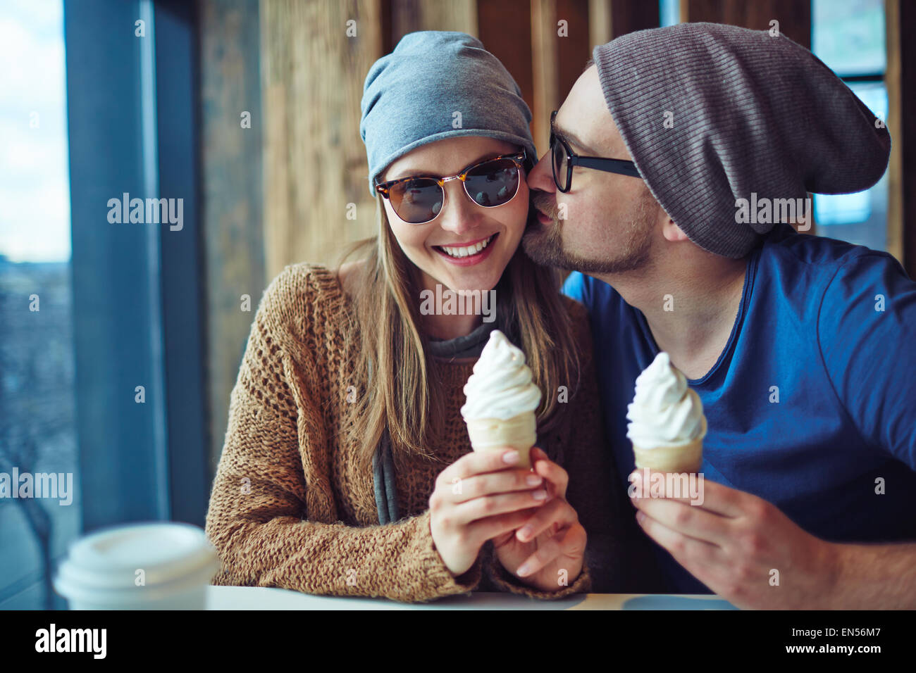 Junger Mann flirtet mit seiner Freundin während mit Eis im café Stockfoto