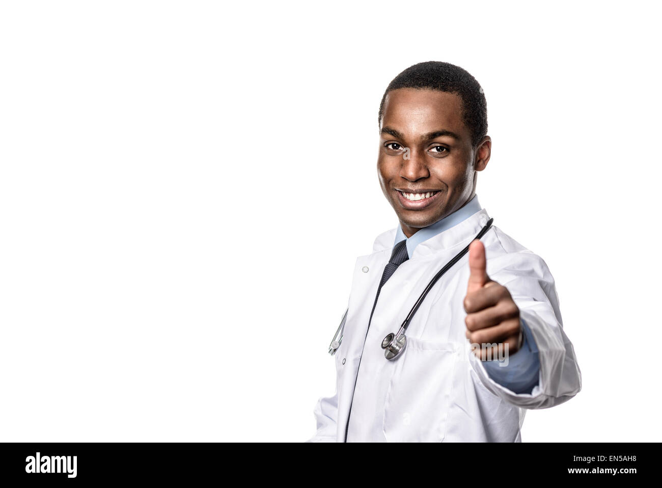 Zuversichtlich afrikanischen Arzt mit einem Stethoskop um den Hals geben einen Daumen nach oben Geste mit einem großen optimistisch Lächeln zu zeigen, eine Schmiere Stockfoto