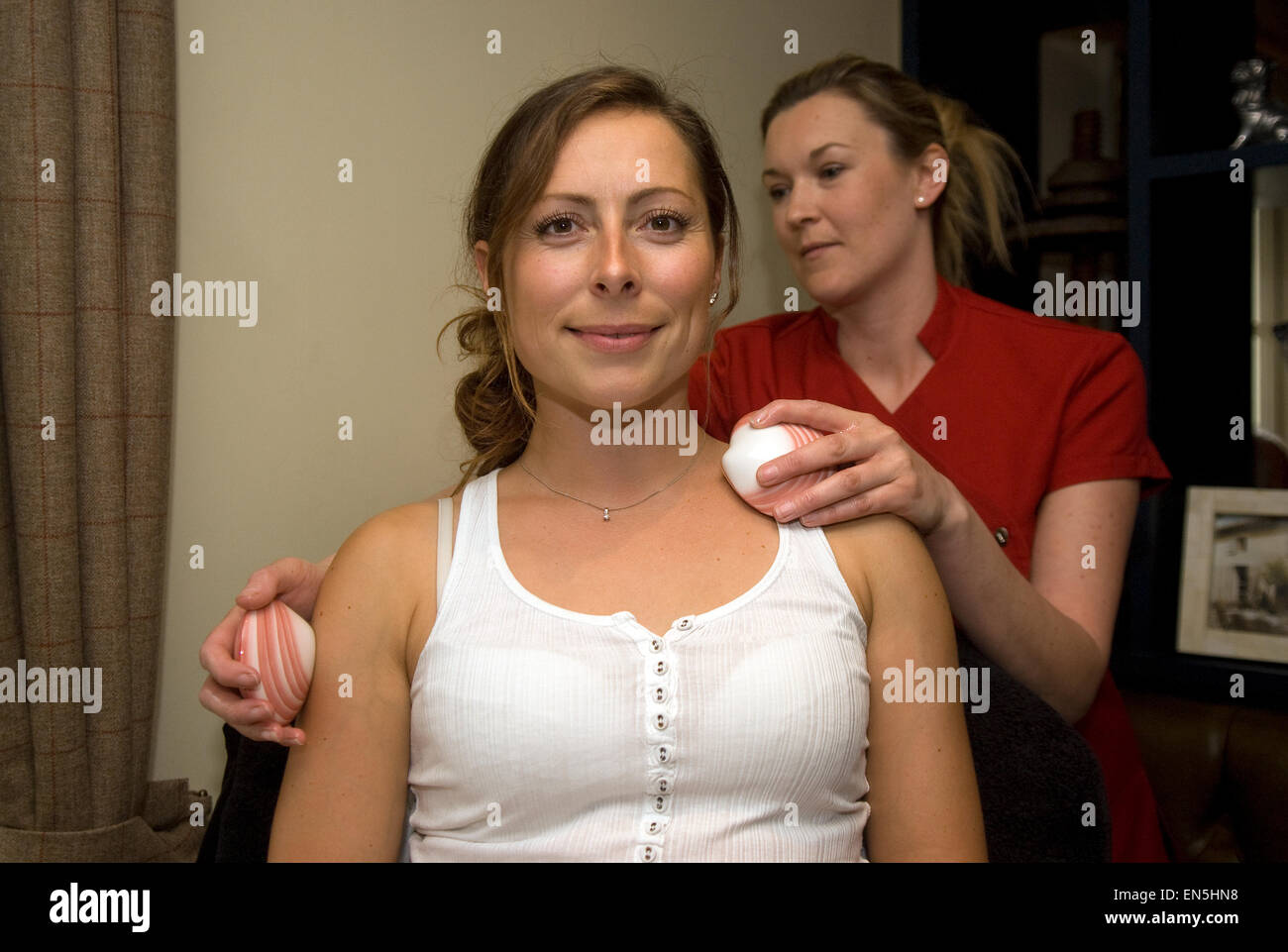 Junge Frau Erhalt einer Lava Shell Massage bei einem Feder-Lifestyle-Event, Liphook, Hampshire, UK. Stockfoto