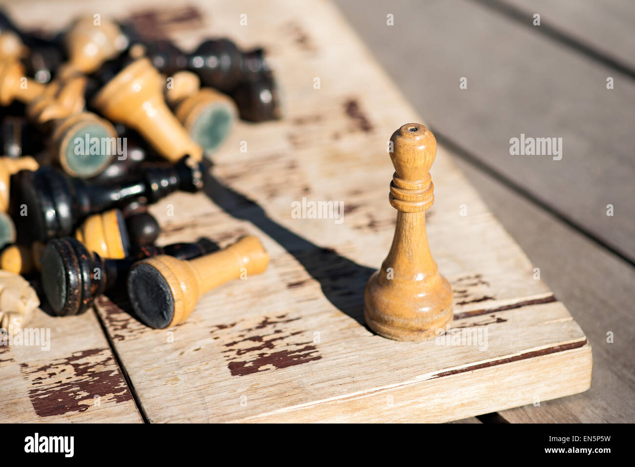 Alt und welk aus Holz Schachkönig auf eine alte und welke Schachbrett. Anderen Schachfiguren von schwarzen und weißen Farbe zu legen, in Haufen Stockfoto