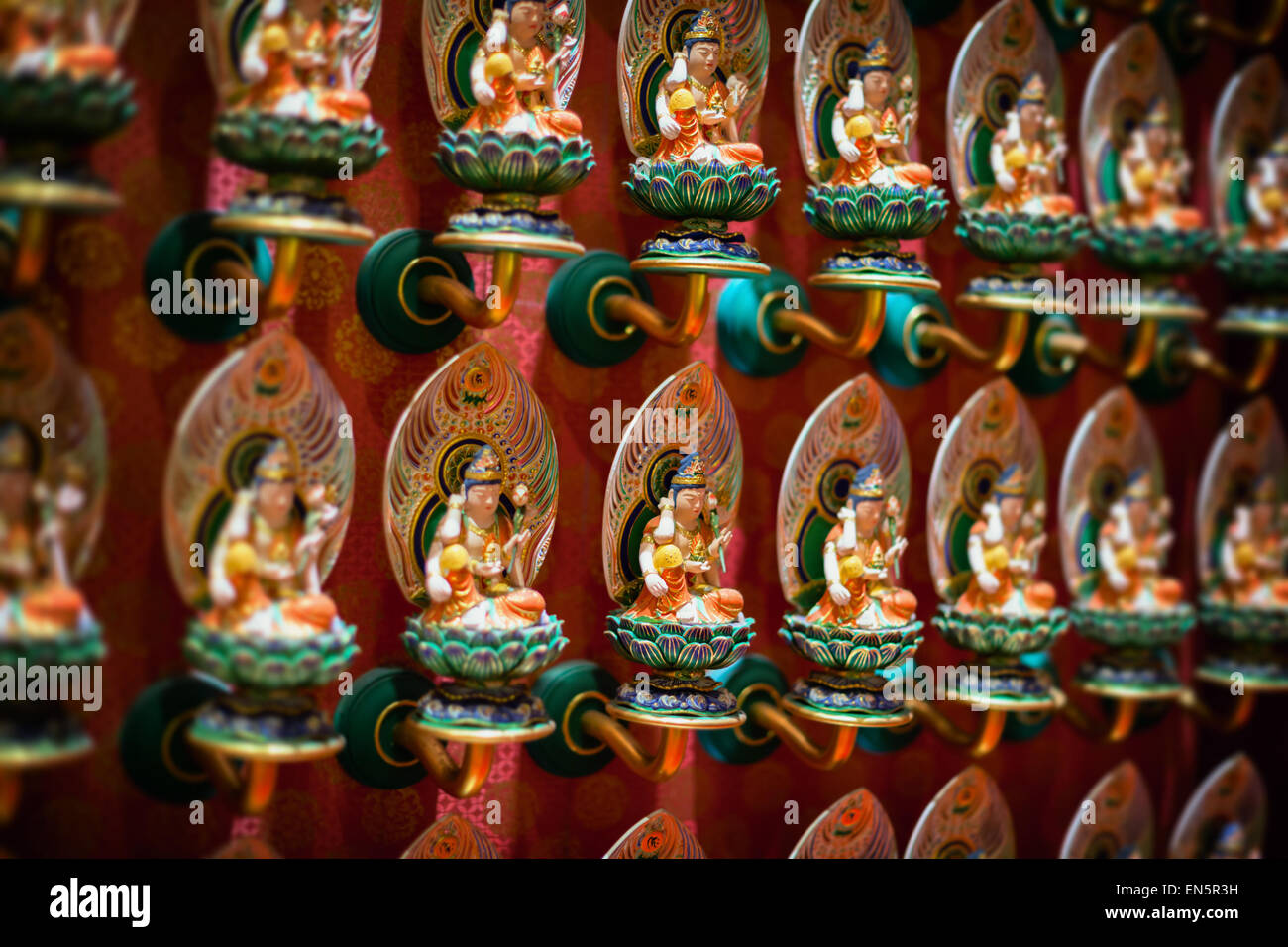 Reihen von schön, kunstvoll geschnitzten und bunt bemalten, identische Skulpturen im Innern der Buddha Tooth Relic Temple in Singa Stockfoto