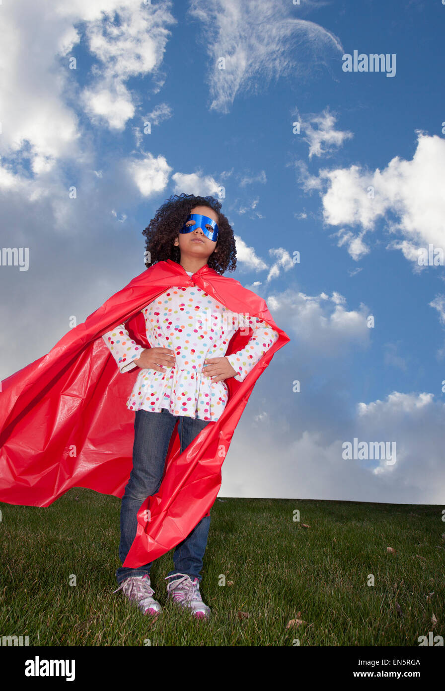 kleine Mädchen Superhelden gegen blauen Himmel Stockfoto