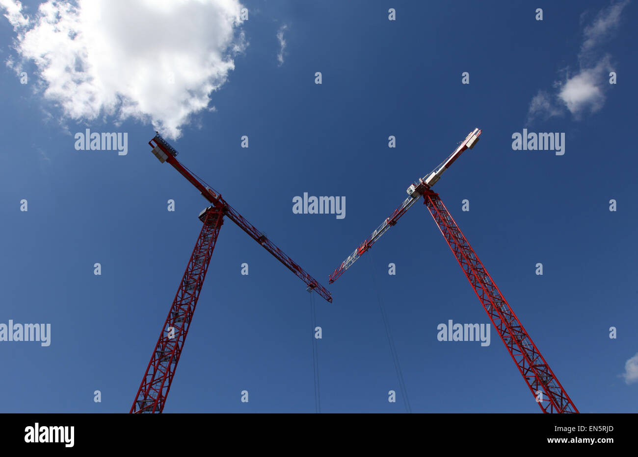 roten Kräne vor einem blauen Himmel auf einer Baustelle Stockfoto