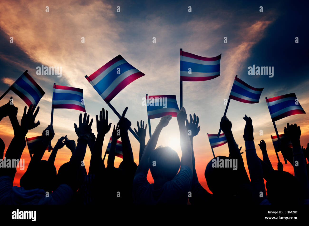 Gruppe von Menschen, die wehende Flagge von Thailand im Gegenlicht Stockfoto