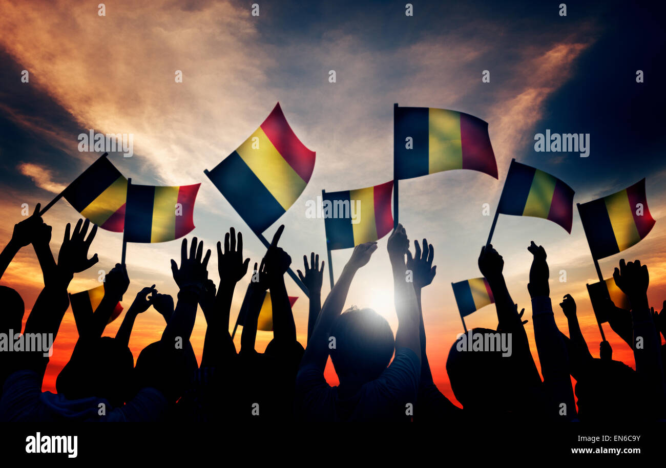 Gruppe von Menschen, die winken belgischen Flaggen im Gegenlicht Stockfoto