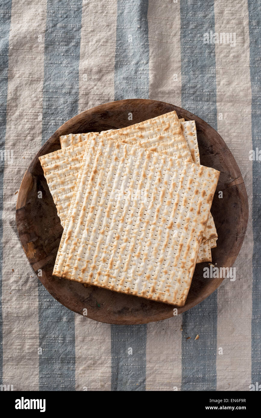 Matza, das ungesäuerte Brot verwendet, in der jüdische Feiertag Pessach, eingestellt auf Holz Schüssel in rustikalem Ambiente Stockfoto