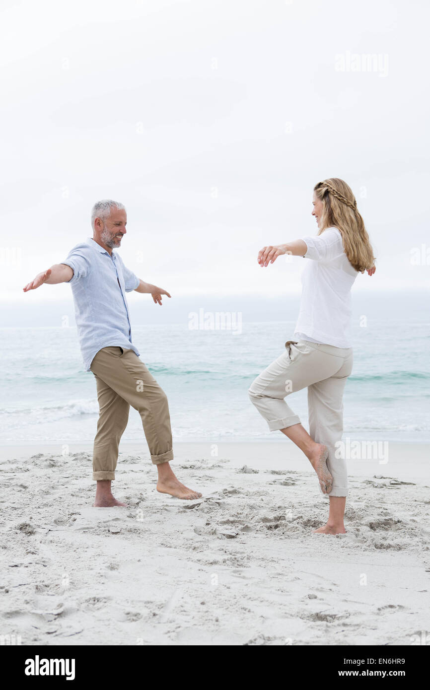 Glückliches Paar Yoga machen darstellen Stockfoto