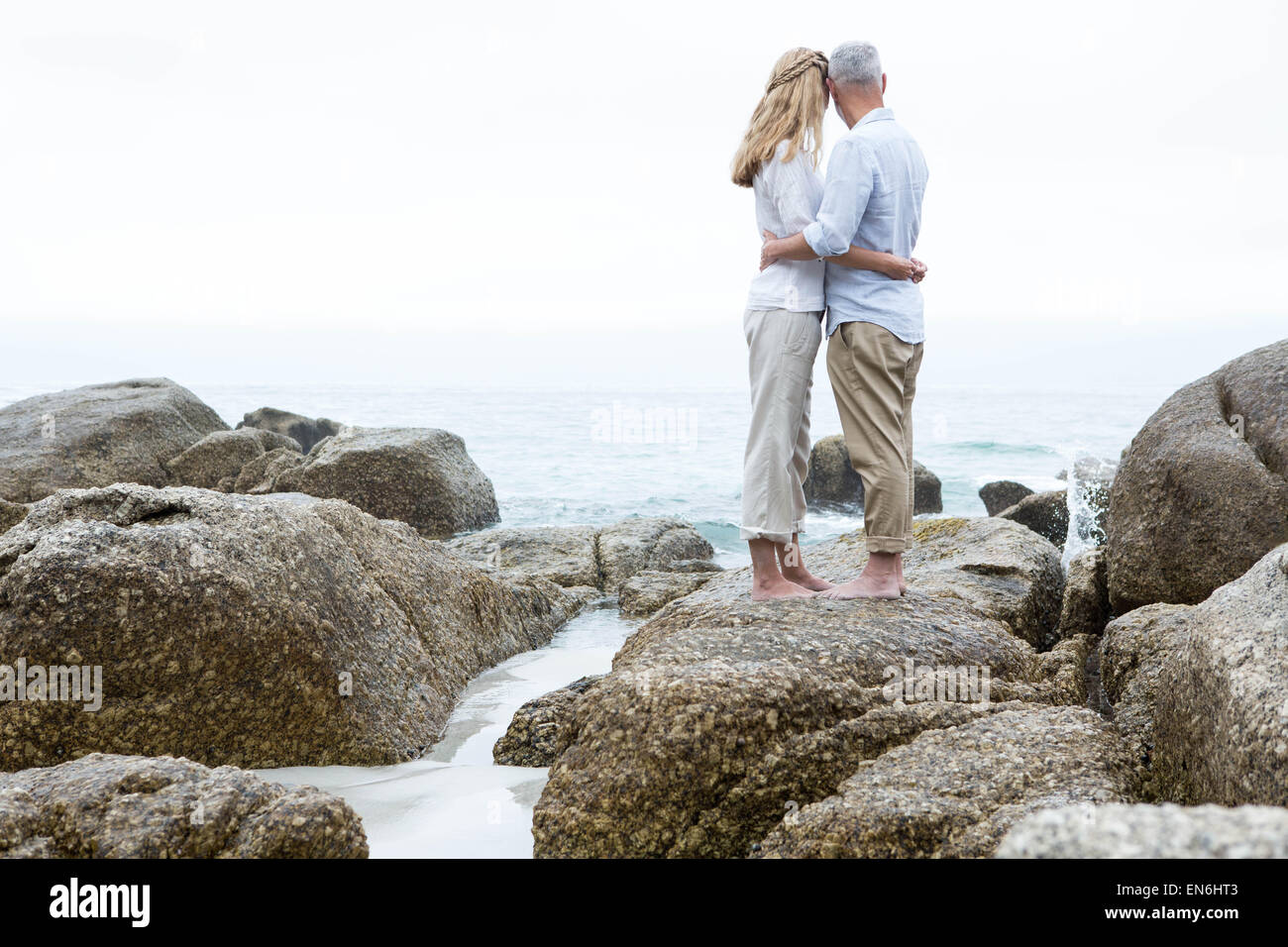 Glückliches Paar auf den Felsen mit Blick auf das Meer Stockfoto