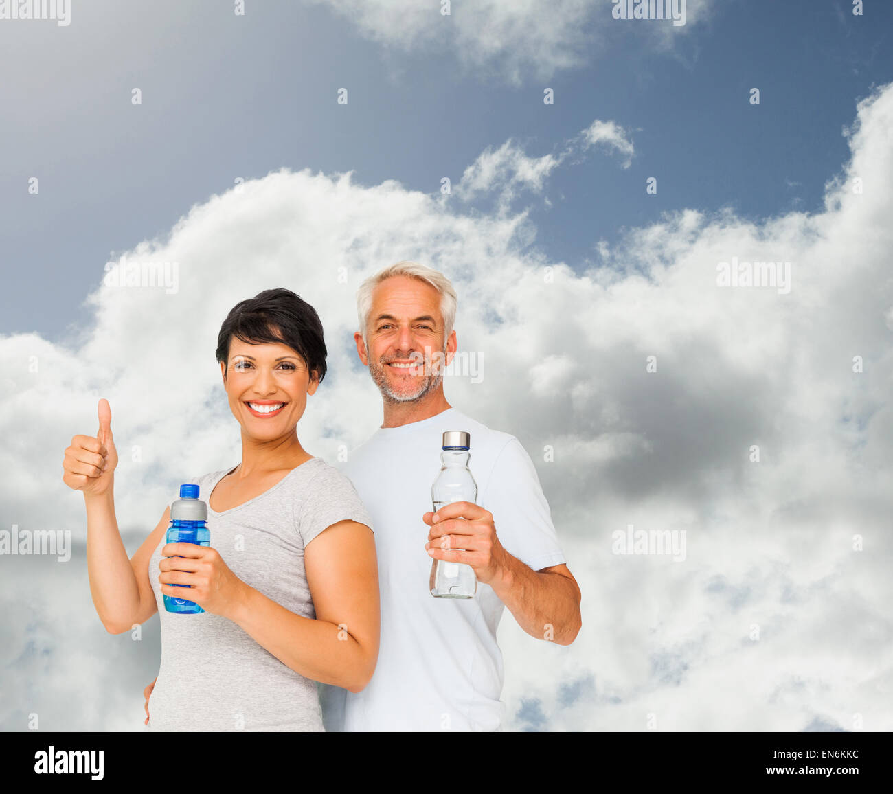 Zusammengesetztes Bild Fit Paares mit Wasserflaschen gestikulieren Daumen nach oben Stockfoto