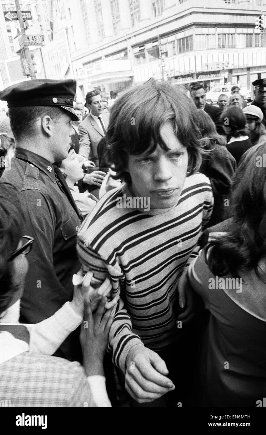Mick Jagger of The Rolling Stones surrounded by fans on Broadway. 2nd June 1964.