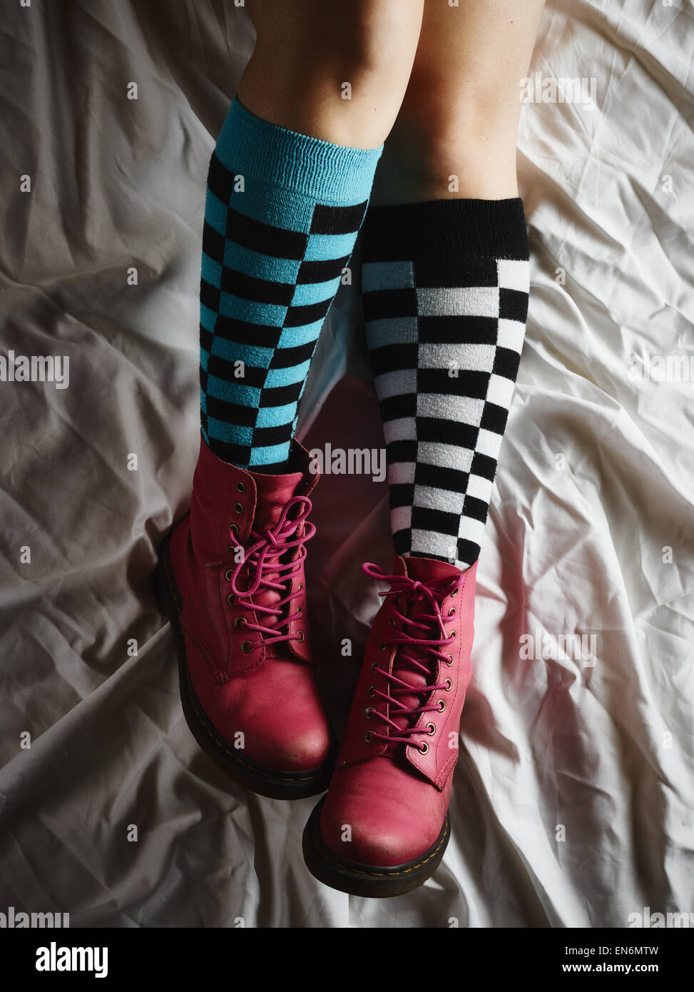 Mädchen liegend auf dem Bett und sie trägt die Socken und die rosa Schuhe Stockfoto