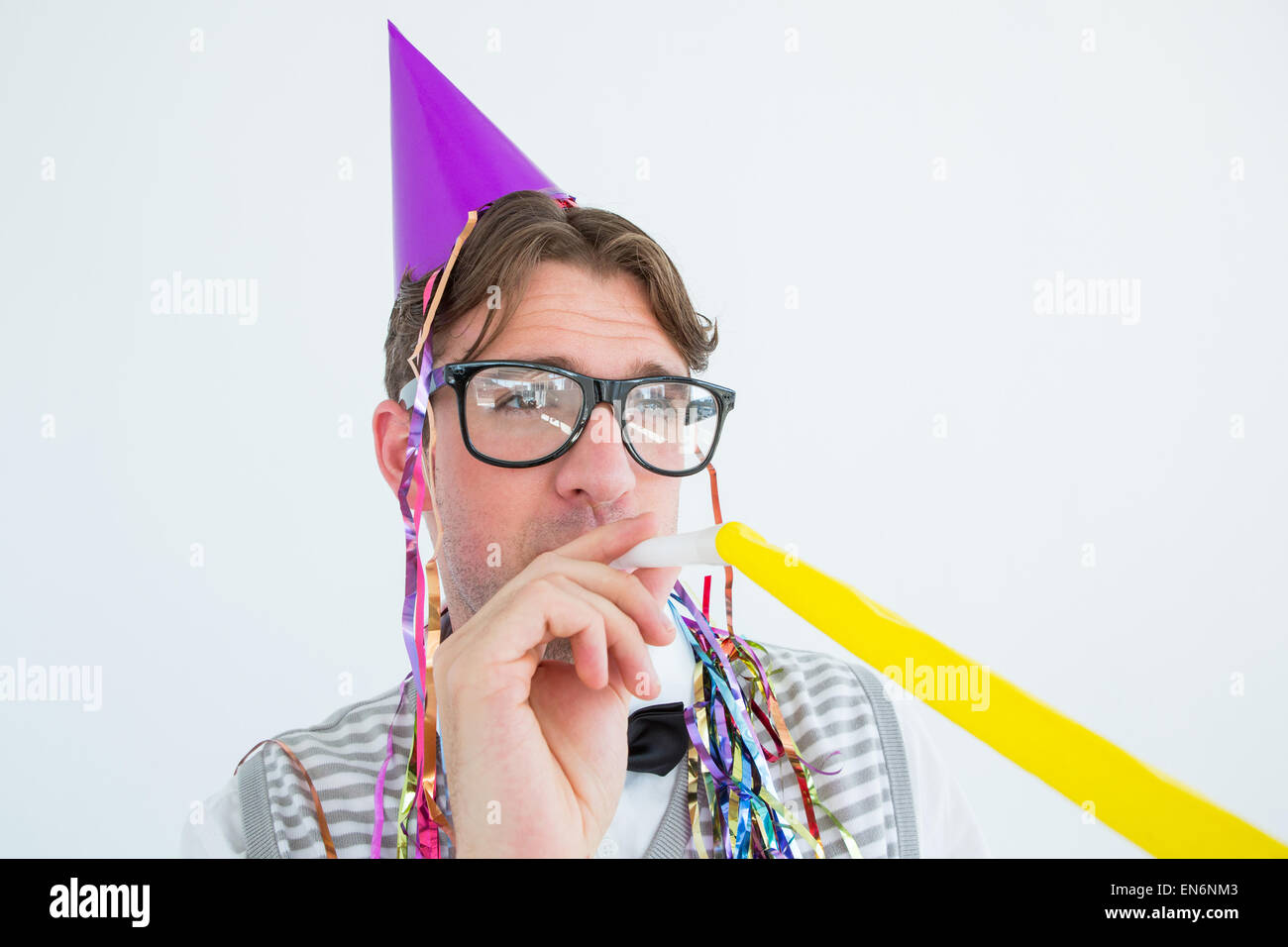 Geeky Hipster einen Party-Hut mit Partei Horn bläst Stockfoto