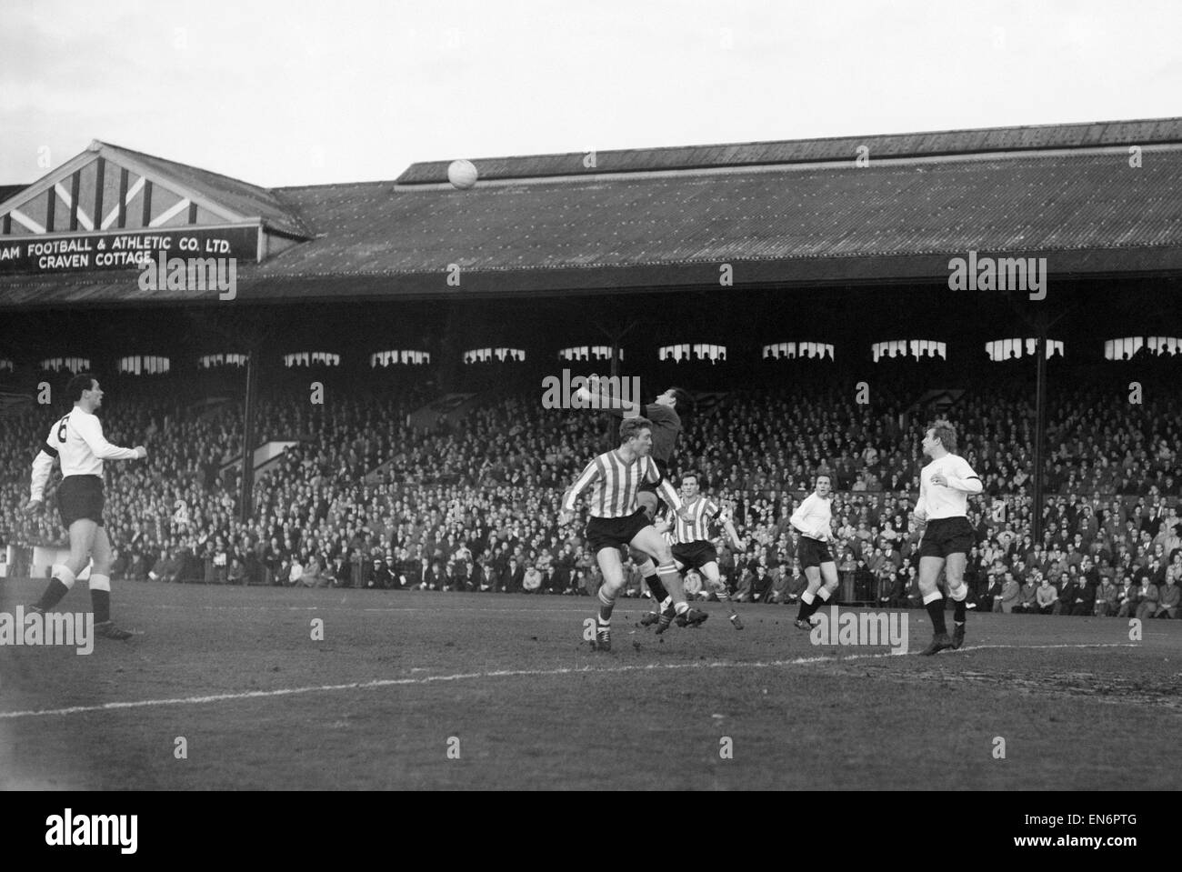 Fulham 3 v. Sheffield United 1. 1964-League-Spiel Macedo, Fulham Torwart Stanzen über Sheffield United vorwärts Derek Pace klar. 23. November 1963 Stockfoto