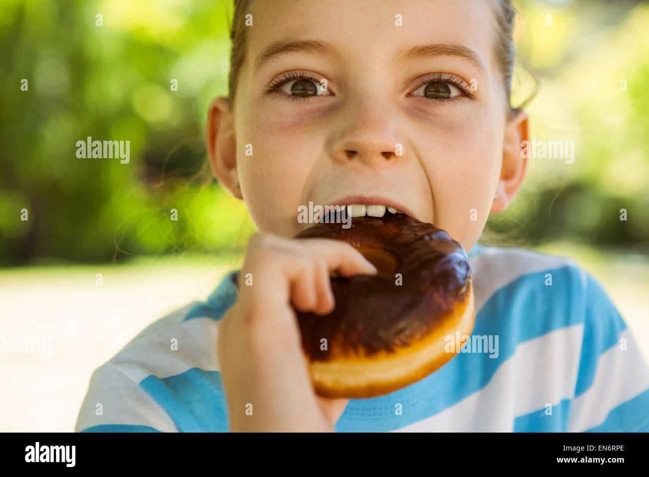 Niedliche kleine Mädchen essen Donut Stockfoto