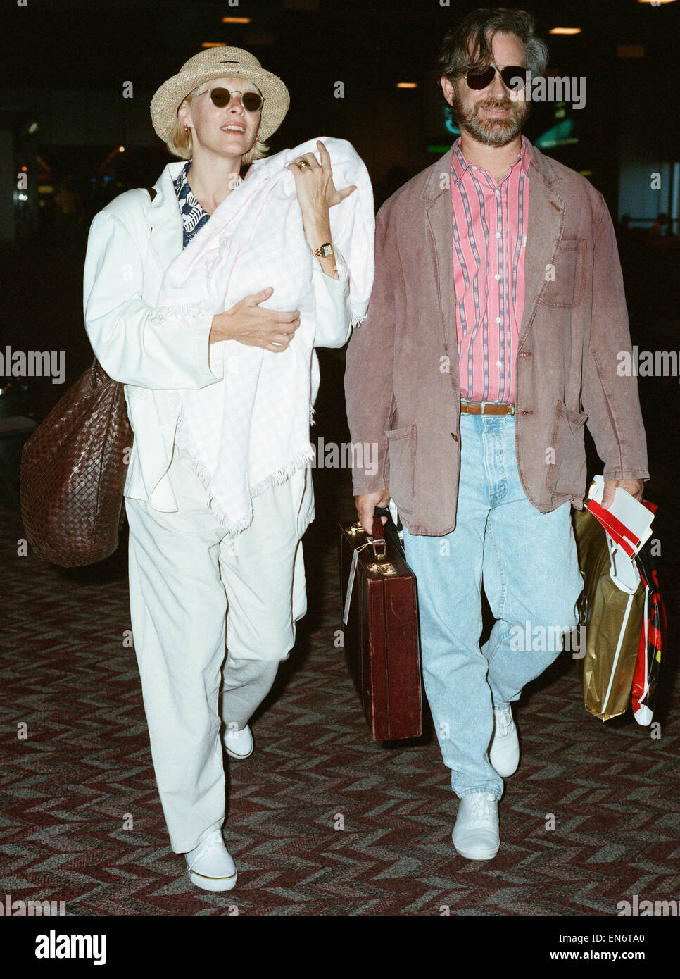Regisseur Steven Spielberg hier am Flughafen Heathrow mit Kate Capshaw mit ihrer neuen Tochter Sasha Rebecca Spielberg zu sehen. 11. Juli 1990 Stockfoto