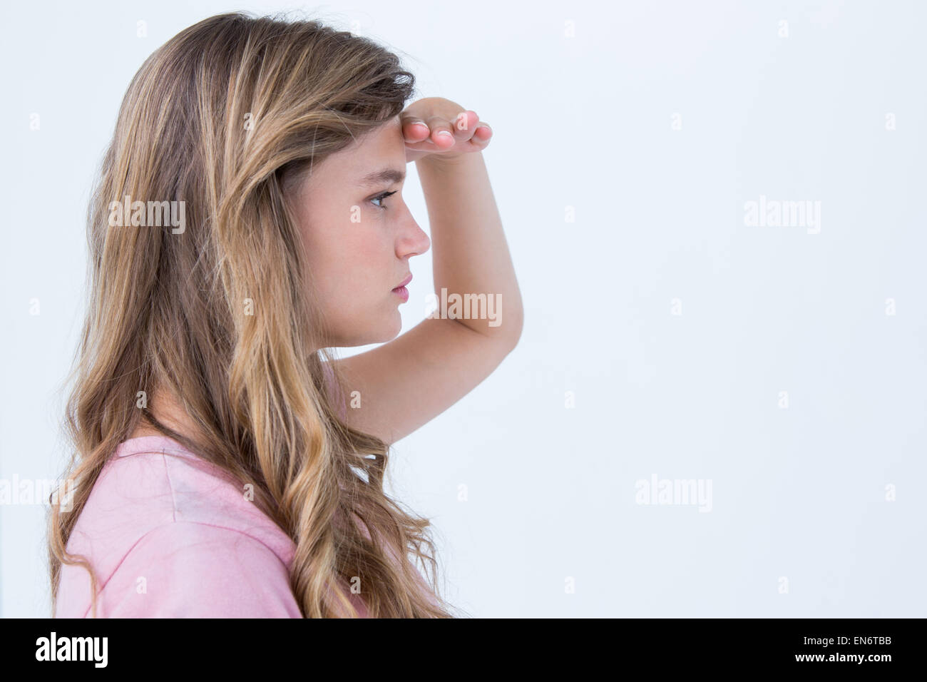 Hübsche Blondine sucht den Horizont mit der Hand auf Stirn Stockfoto