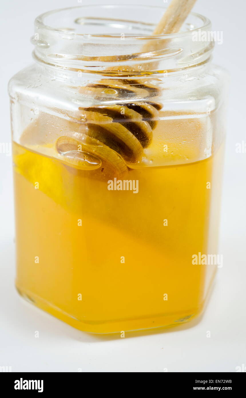Glas Honig mit einem Wagen drin auf weißem Hintergrund Stockfoto