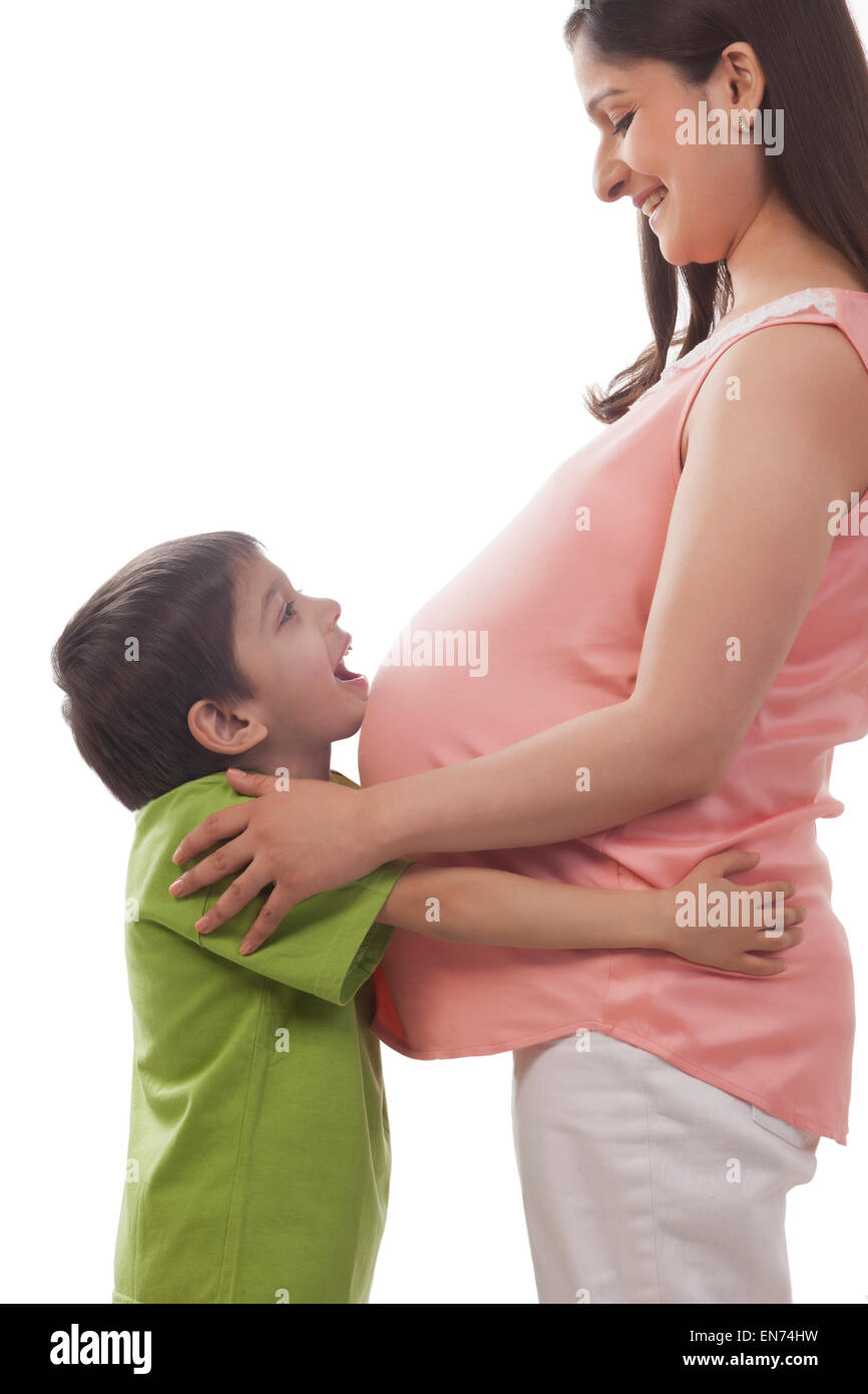Junge Ruhe Kinn auf Bauch der schwangeren Mutter Stockfoto