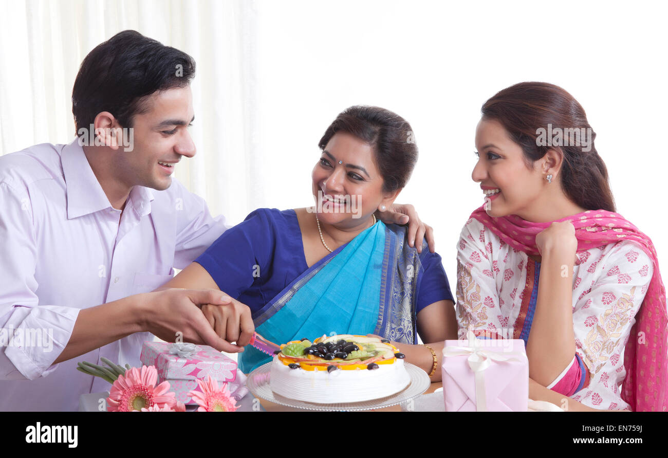 Frau schneiden Geburtstagskuchen mit einem Messer Stockfoto