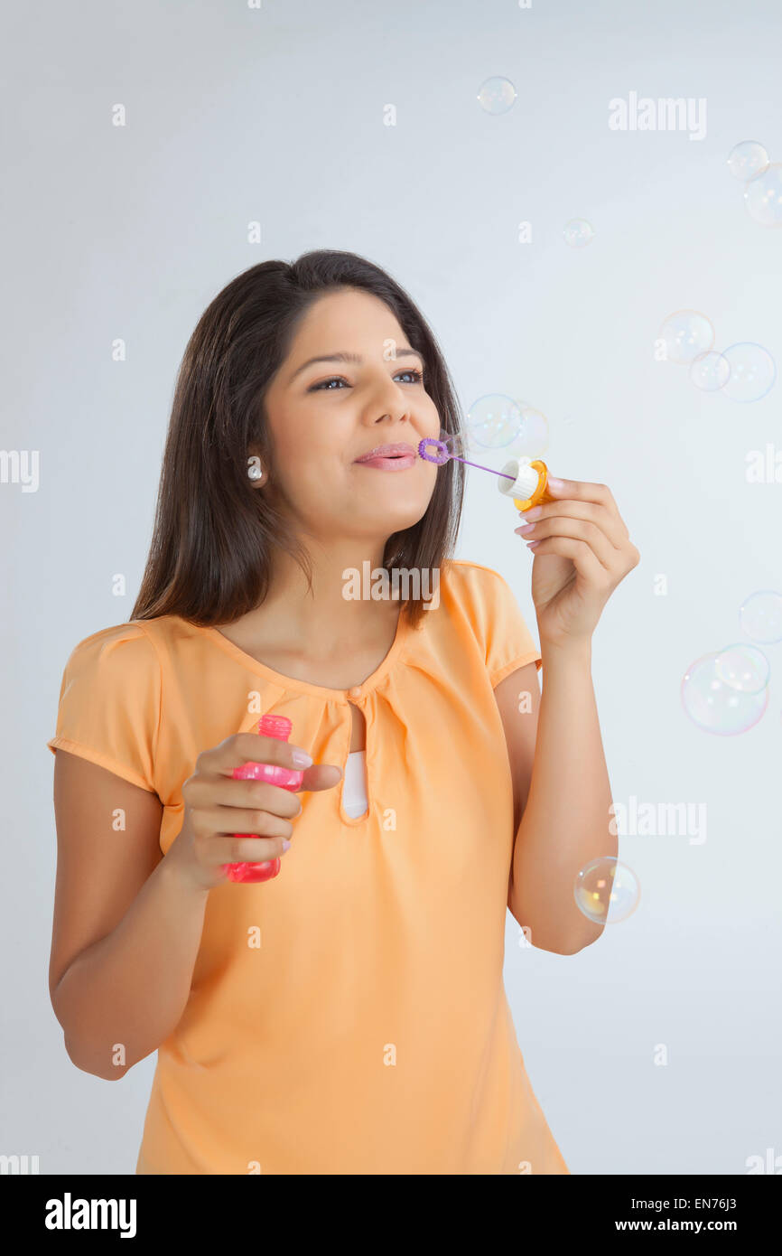 Junge Frau bläst Seifenblasen Stockfoto