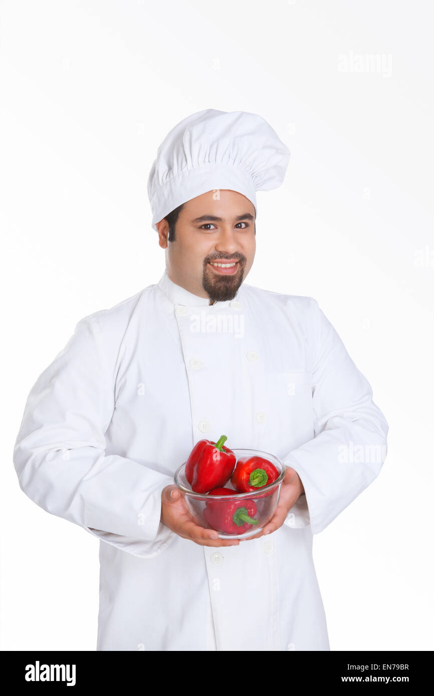 Portrait des Küchenchefs mit Schüssel mit roter Paprika Stockfoto