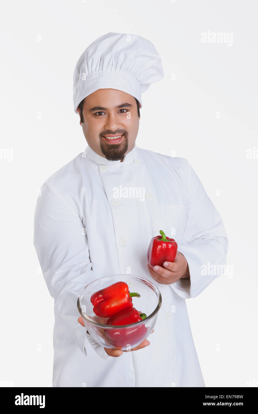 Portrait des Küchenchefs mit Schüssel mit roter Paprika Stockfoto