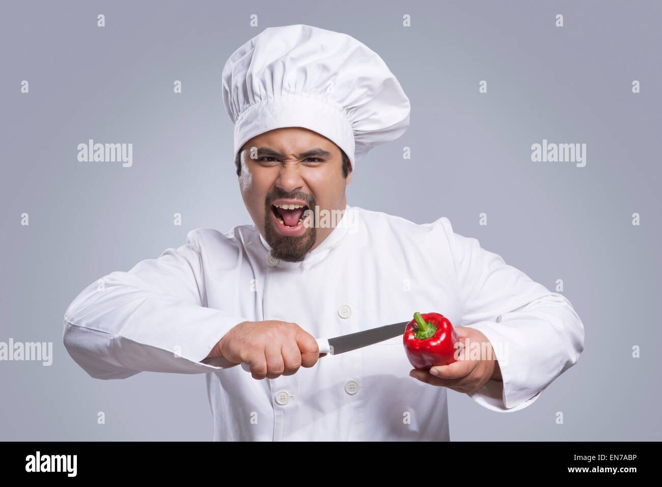 Porträt von Küchenchef schneiden Paprika mit Messer Stockfoto