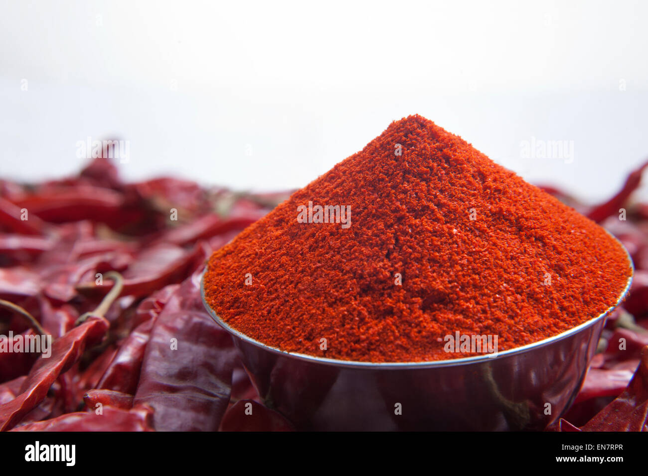Nahaufnahme von Chili-Pulver in Schüssel und rote Chilischoten Stockfoto