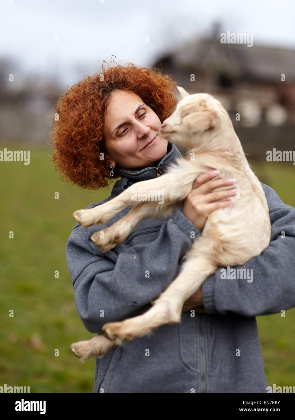 Bauer-Frau hält eine niedliche Baby-Ziege im freien Stockfoto