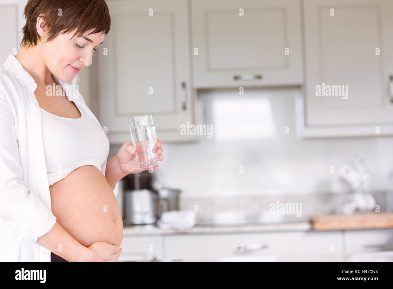 Schwangere Frau Glas Wasser trinken Stockfoto