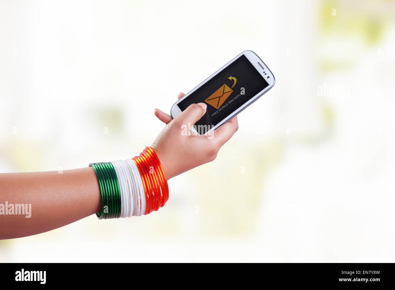 WoMans Hand mit Armreifen in den Farben der Nationalflagge mit Handy Stockfoto