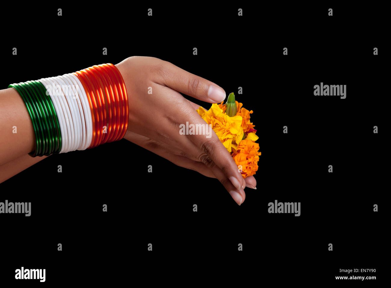 WoMans Hände mit Armreifen in den Farben der Nationalflagge mit Blumen Stockfoto