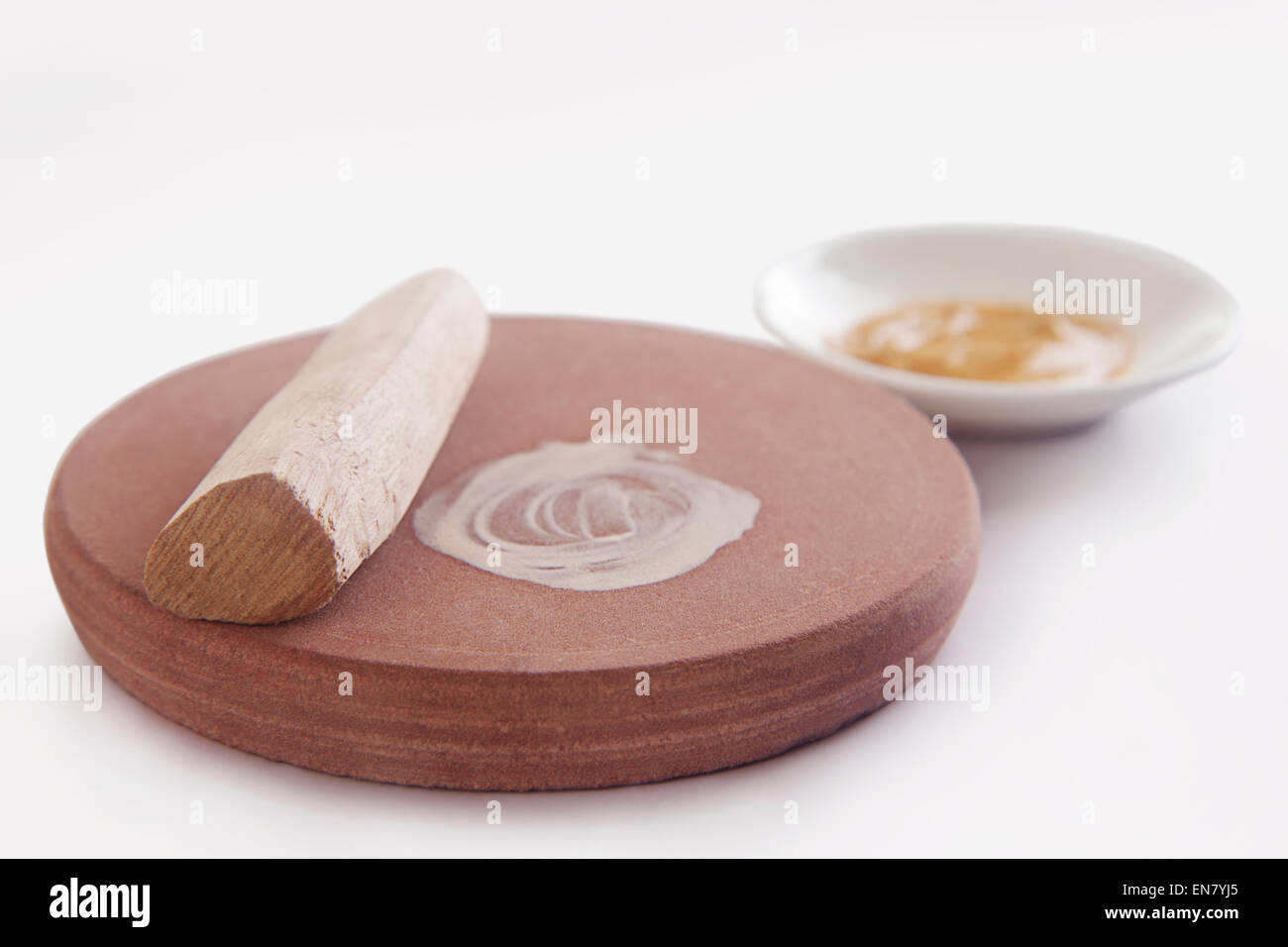 Sandelholz-Stick mit Steinmühle und Sandelholz Paste in eine Schüssel geben Stockfoto