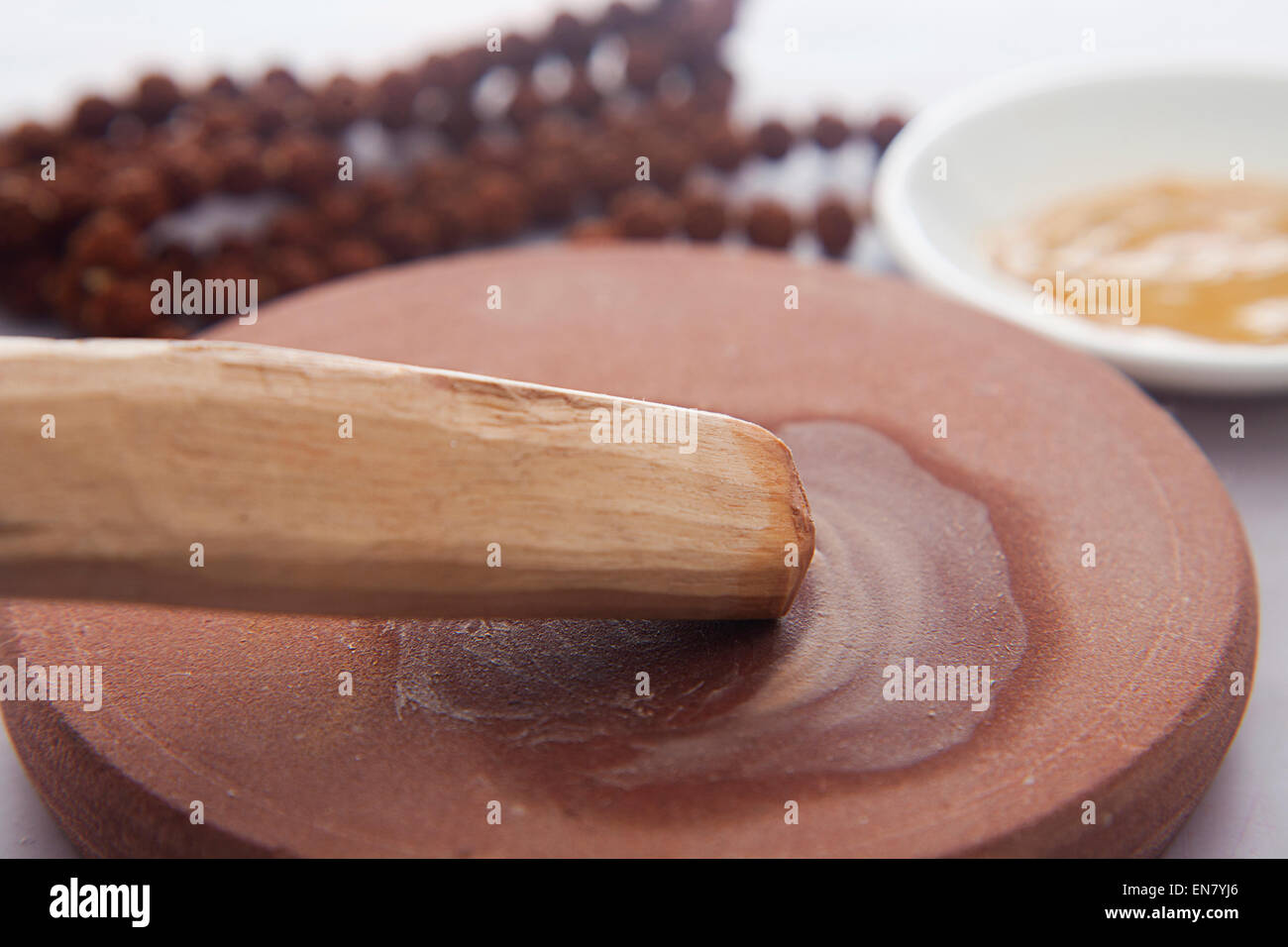 Sandelholz-Stick mit Steinmühle, Sandelholz paste in eine Schüssel geben und mala Stockfoto
