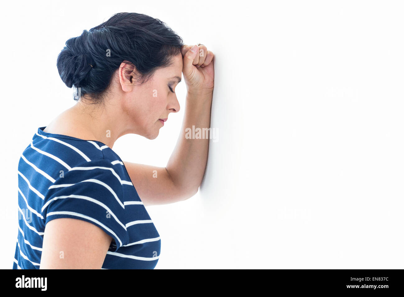 Traurige Frau an die Wand gelehnt Stockfoto
