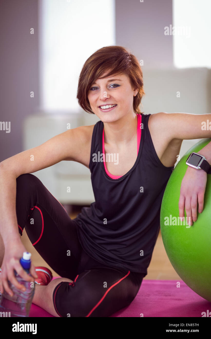 Fit Frau sitzt neben Gymnastikball Stockfoto