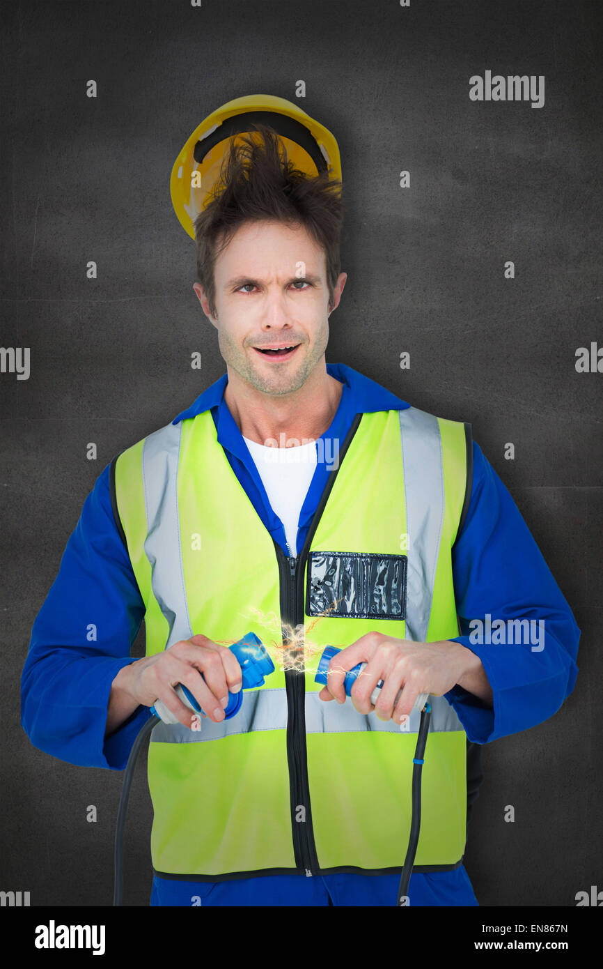 Zusammengesetztes Bild des Elektrikers immer einen Schock Kabel mit gedrückter Stockfoto