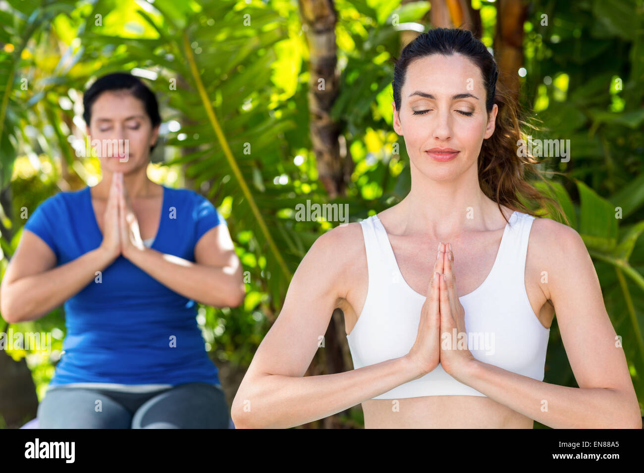 Entspannte Frau und ihr Trainer Yoga machen Stockfoto