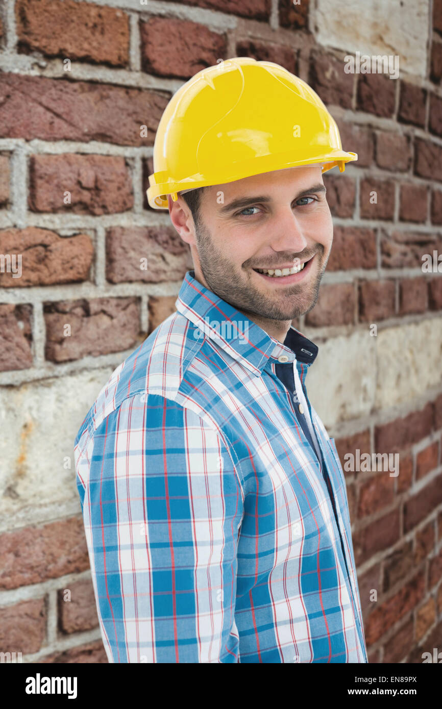 Zusammengesetztes Bild zuversichtlich Mechaniker Schutzhelm tragen Stockfoto